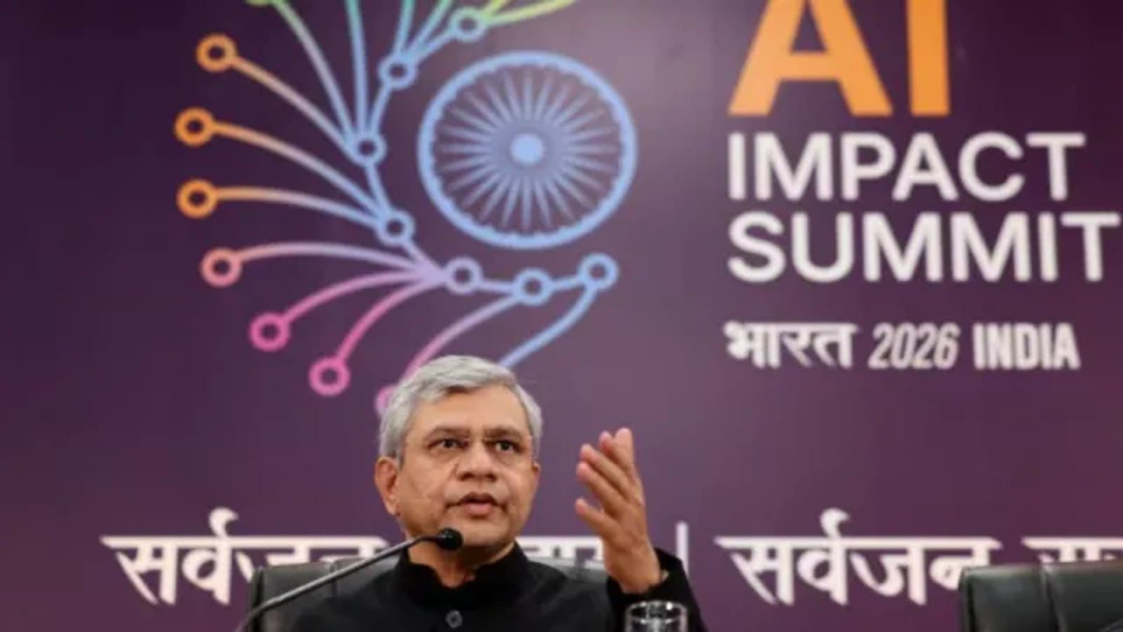 Union Electronics and IT Minister Ashwini Vaishnaw speaking in front of the AI Impact Summit 2026 India backdrop.
