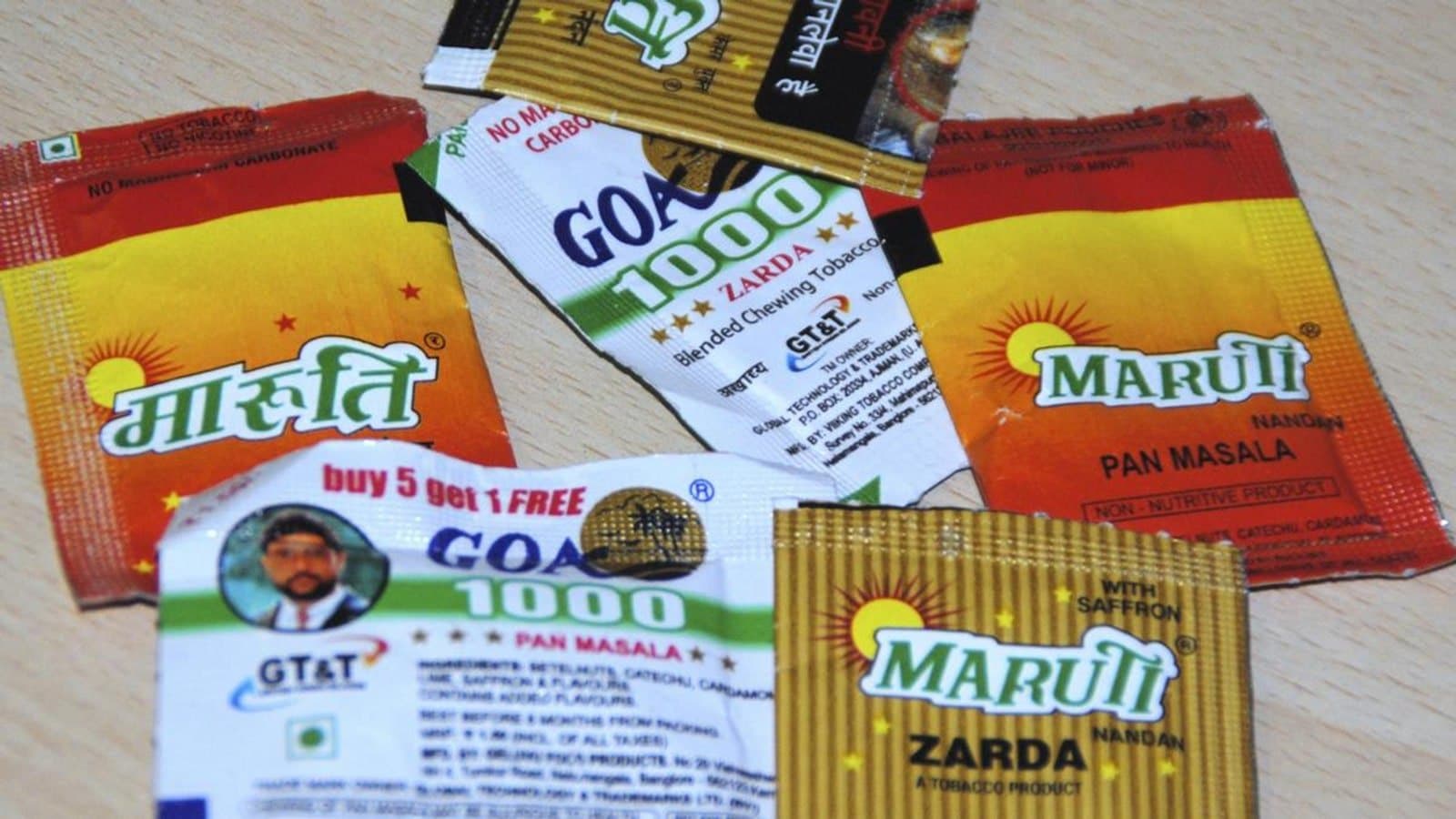 Empty sachets of pan masala and chewing tobacco of various brands laid out on a wooden surface. फाइल फोटो।
