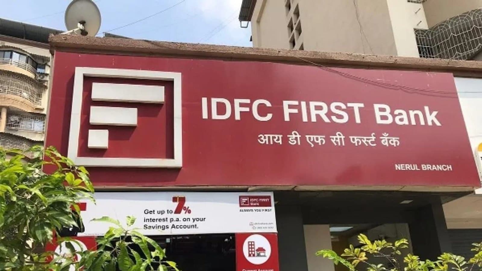 Signage above an IDFC First Bank branch, with a savings account interest rate board below it.