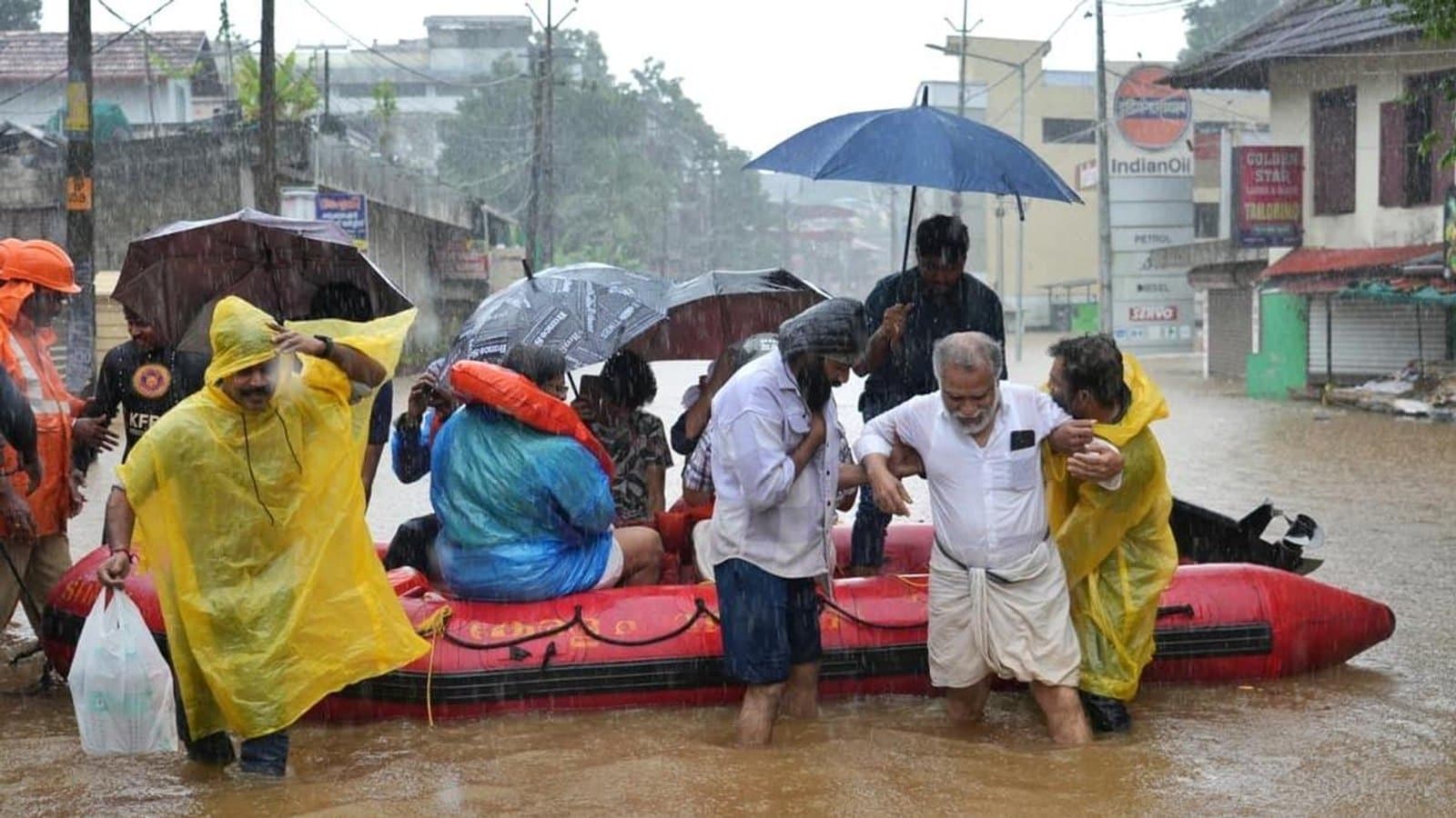 Rescue workers helping an elderly man through knee deep floodwater beside an inflatable boat in heavy rain at Ranni, Pathanamthitta. फाइल फोटो।