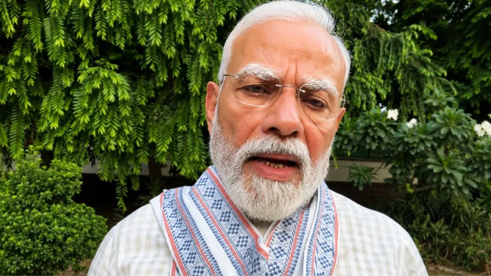 Prime Minister Narendra Modi speaking outdoors, with trees and shrubs behind him. फाइल फोटो।