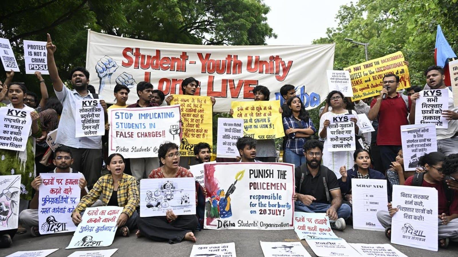 Students seated on a road at a protest holding placards and banners reading Student Youth Unity Long Live, Stop Implicating Students in False Charges and Punish the Policemen. फाइल फोटो।