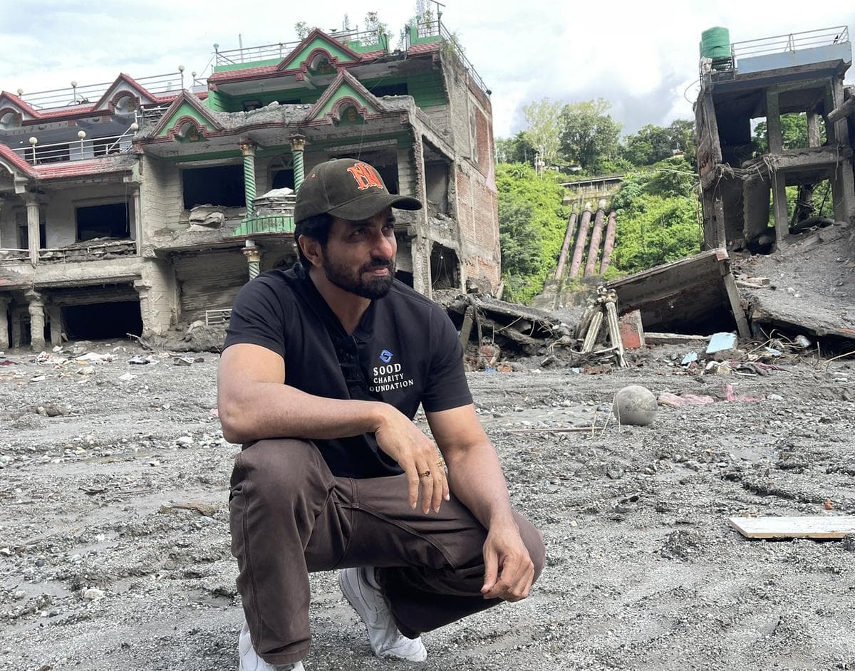 Sonu Sood crouches near flood damaged buildings during his visit to Nepal